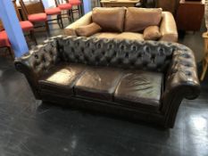A brown leather Chesterfield three seater settee