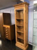 A tall narrow pine and glazed cabinet, 68cm wide