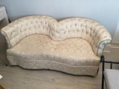 An Edwardian two seater 'Love' settee, with curved and button back, curved arms and supported on