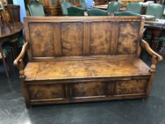 A long oak four panelled settle, with rising seat, 164cm wide