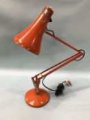 An orange angle poise Lighting Ltd lamp