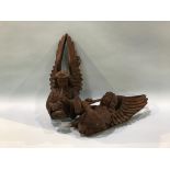 A pair of carved Ecclesiastical trumpeting winged angels, 37cm length