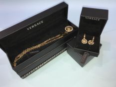 A boxed Versace pair of earrings and a necklace