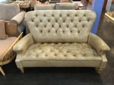A beige leather Chesterfield style settee