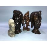 A pair of carved tribal busts, a hardwood Oriental carved figures and a soapstone bust