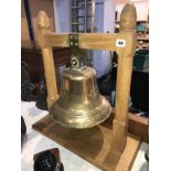 A large ships bell on light oak stand, off 'The Crista 1938'