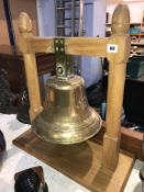 A large ships bell on light oak stand, off 'The Crista 1938'