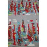 A roll of fabric with striking vibrant abstract design in red, yellow and turquoise, with red