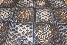 A bale of fabric, decorated with dark blue geometric squares and orange and pale blue. 116cm wide