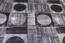 A roll of fabric, with black and white geometric squares and circles. 123cm wide x 14 metres long