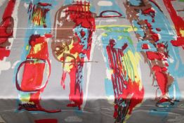 A piece of fabric with striking vibrant abstract design in red, yellow and turquoise, with red