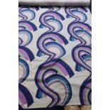 A roll of pale mint green fabric, with psychedelic pattern in purple, green and blue, 173cm wide x