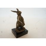 Bronze rabbit holding flowers on marble base