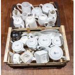 Two trays containing white teapots and jugs