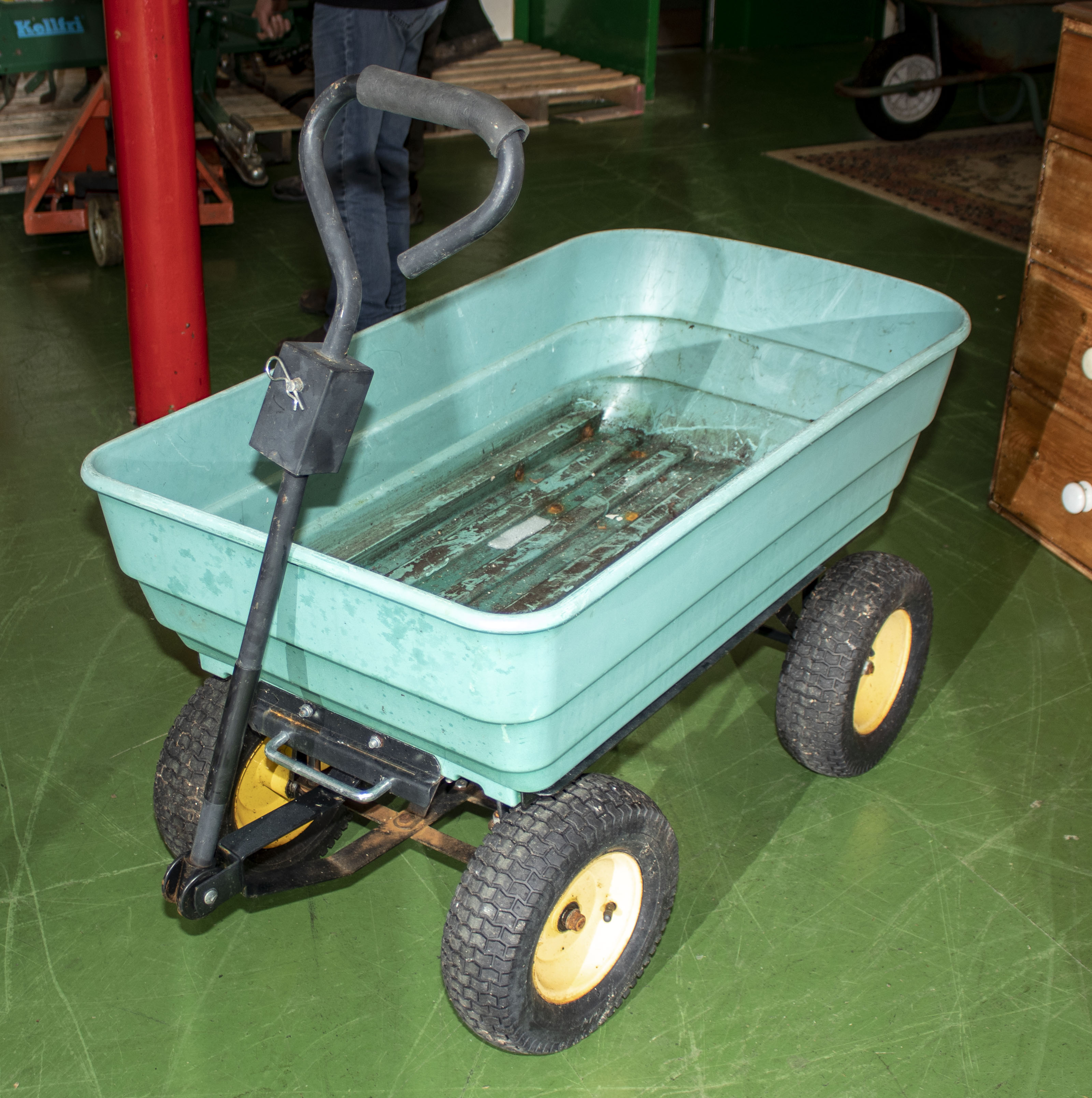 A green plastic four wheel garden truck