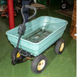 A green plastic four wheel garden truck