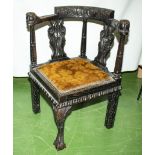 A heavily carved Victorian oak corner chair with ball and claw front leg with carved knee, carved