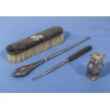 A silver and ebony backed brush, boot hooks and a small owl pepperette