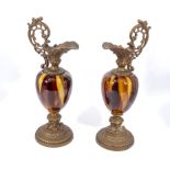 A pair of marbled pottery and gilt ewers, 38cm tall