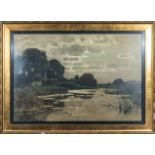 A gilt framed print depicting a river scene