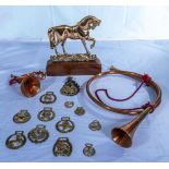 A brass horse door stop, horns and horse brasses