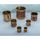 A set of seven antique copper corn measures