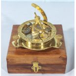 A brass sundial compass in wooden box