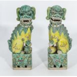 A pair of Chinese temple dogs green and yellow glaze, 23cm tall