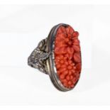 A white metal and carved coral ring