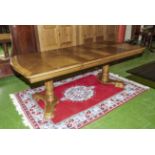 A 20th century wind out oak dining table with two inserts