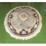 A large oval decorative Indian Aubusson style wool rug, grey ground with floral pattern