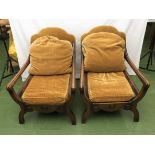 A pair of oak armchairs with open arms and mustard cushions