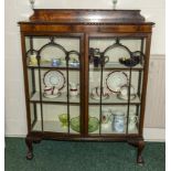 A 1930s mahogany display cabinet with ball and claw feet