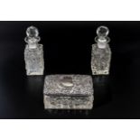 A silver lidded glass box and two crystal scent bottles