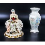 A porcelain figure of a lady and a vase