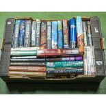 A box of novels by Clive Cussler, Jack Higgins and others