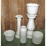 A collection of white pottery jardinieres and stands