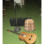 A guitar, microphone stand, case and musical instrument