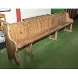 An antique pitch pine church pew 9.5 feet long