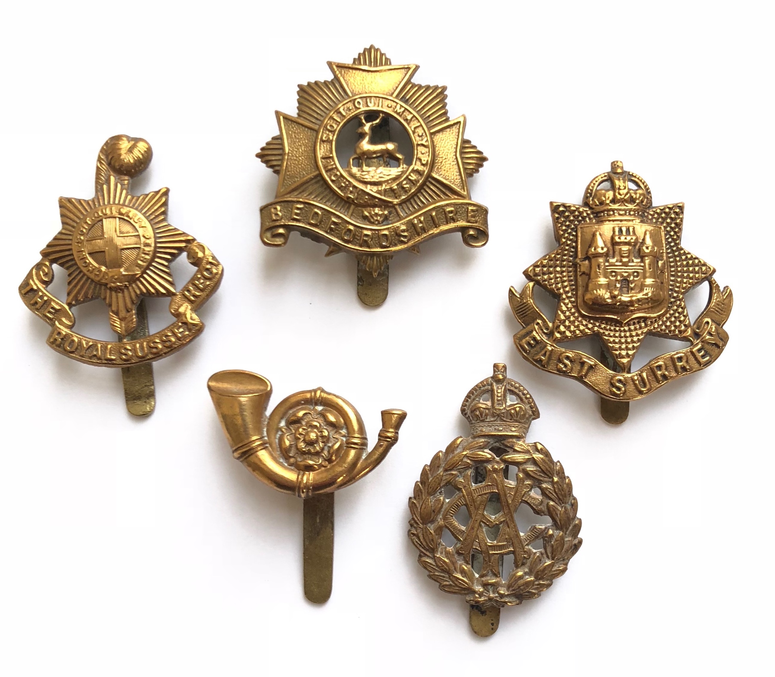 5 WW1 all brass economy cap badges circa 1916-18. Royal Sussex ... Bedfordshire ... East