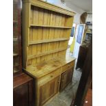 A Victorian pine dresser having a three tier plate rack above drawers and cupboard doors 215cm h x