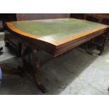 A reproduction green leather topped coffee table having lyre end supports, 53.5cm h x 135cm w