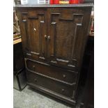 An early 20th century oak dressing chest having two cupboard doors revealing slide art shelves and