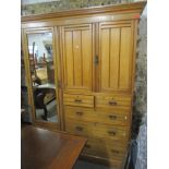 A late 19th/early 20th century ash wardrobe having a stepped cornice with a mirrored door, two