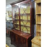 A mid 19th century mahogany bookcase having a stepped cornice above two astragal glazed doors with