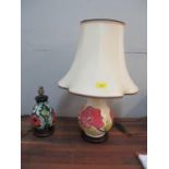 A Moorcroft poppy pattern table lamp of inverted baluster form, mounted on a wood effect base,