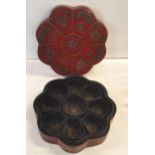 A Chinese red and black lacquered octagonal box housing nine segments, decorated with bats and