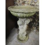 A garden composition bird bath, the column in the form of three cherubs and raised on a circular