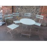 A painted wooden slated folding garden table and four chairs