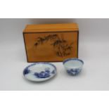 A Chinese Nanking Cargo blue and white tea bowl and saucer, each decorated with a landscape,